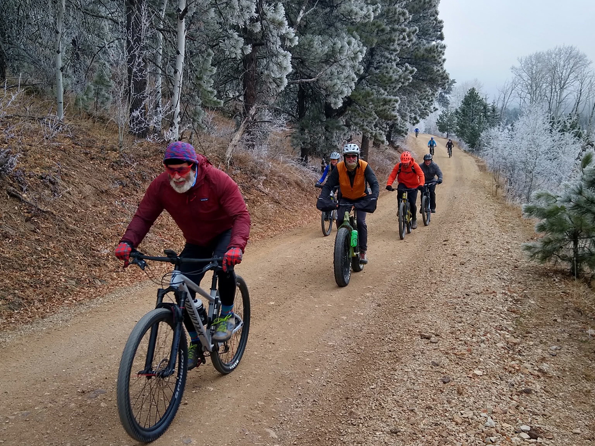 Group of adult bicyclists riding a trail in the black hills on a frosty morning