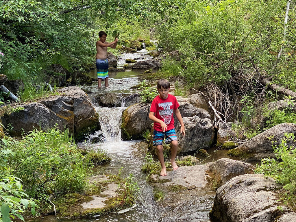 Playing in the creek and small waterfalls along Elk Creek Trail near Piedmont, SD