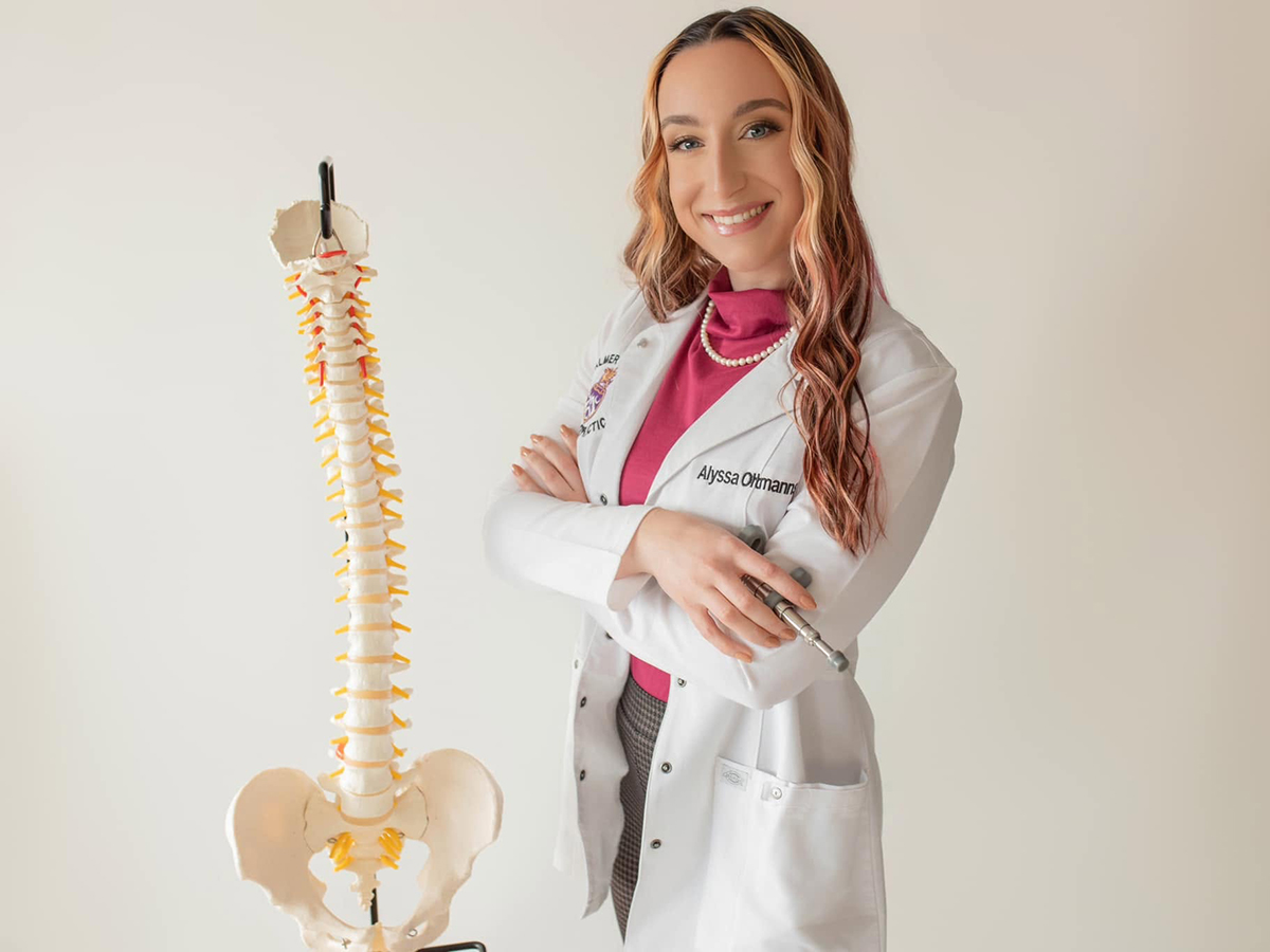 Dr. Aly Oltmanns of Canyon Chiropractic, Spearfish, posing with a model of spine.