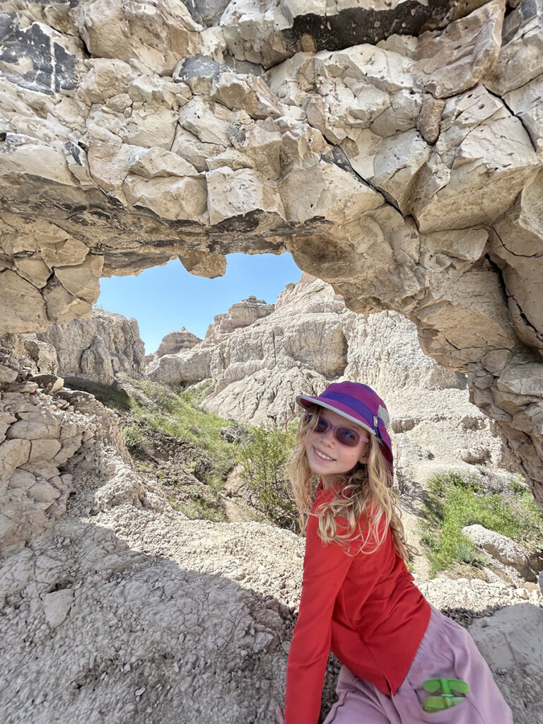 Logan S. daughter posing at a rock formation during a hike.