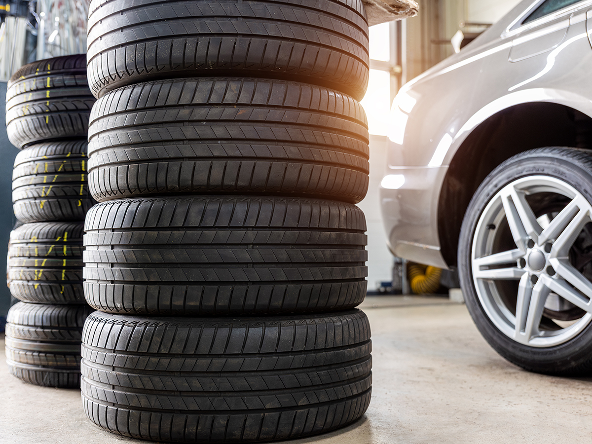 Hills Tire & Supply Car in Shop Bay with stack of tires