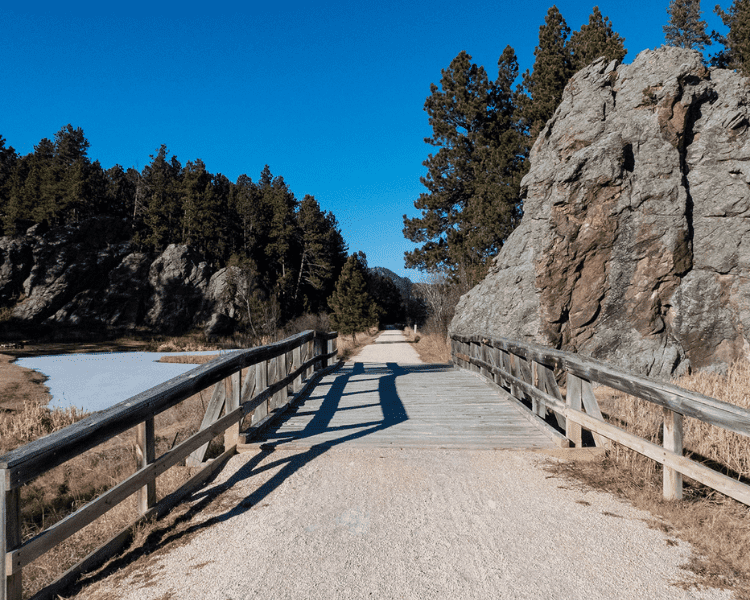Mickelson Trail - Harbach Park Trailhead wooden pathway surrounded by large rock formations
