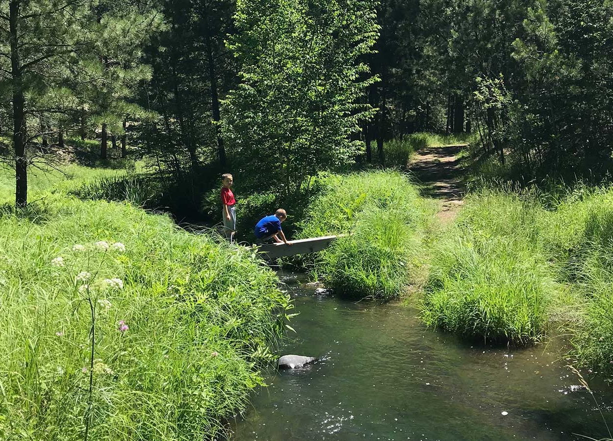 boys crossing creek at grace coolidge trail